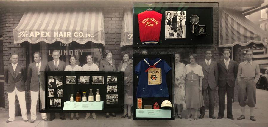Photograph of Working Life in a Resort City exhibit case with photographs and artifacts depicting the Apex Hair Company, local dairies, Captain Starn's restaurant, Hackney's restaurant, Atlantic City Fire Department, Atlantic City Police Department, Steeplechase Pier, Al Gold, Showboat Hotel Casino, and other workers in the city.